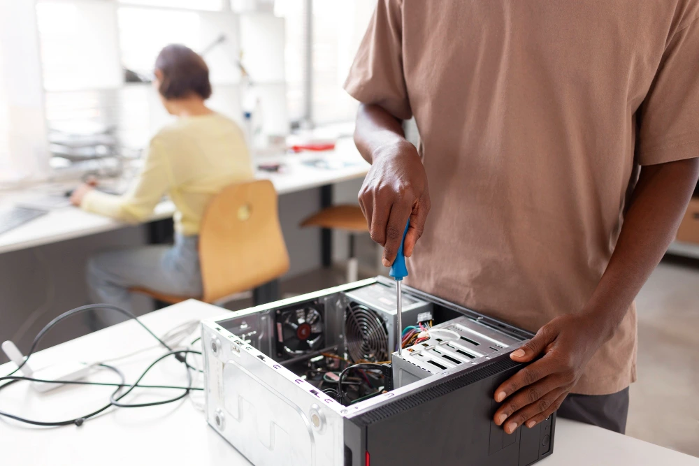 Technician repairing a desktop computer for IT maintenance